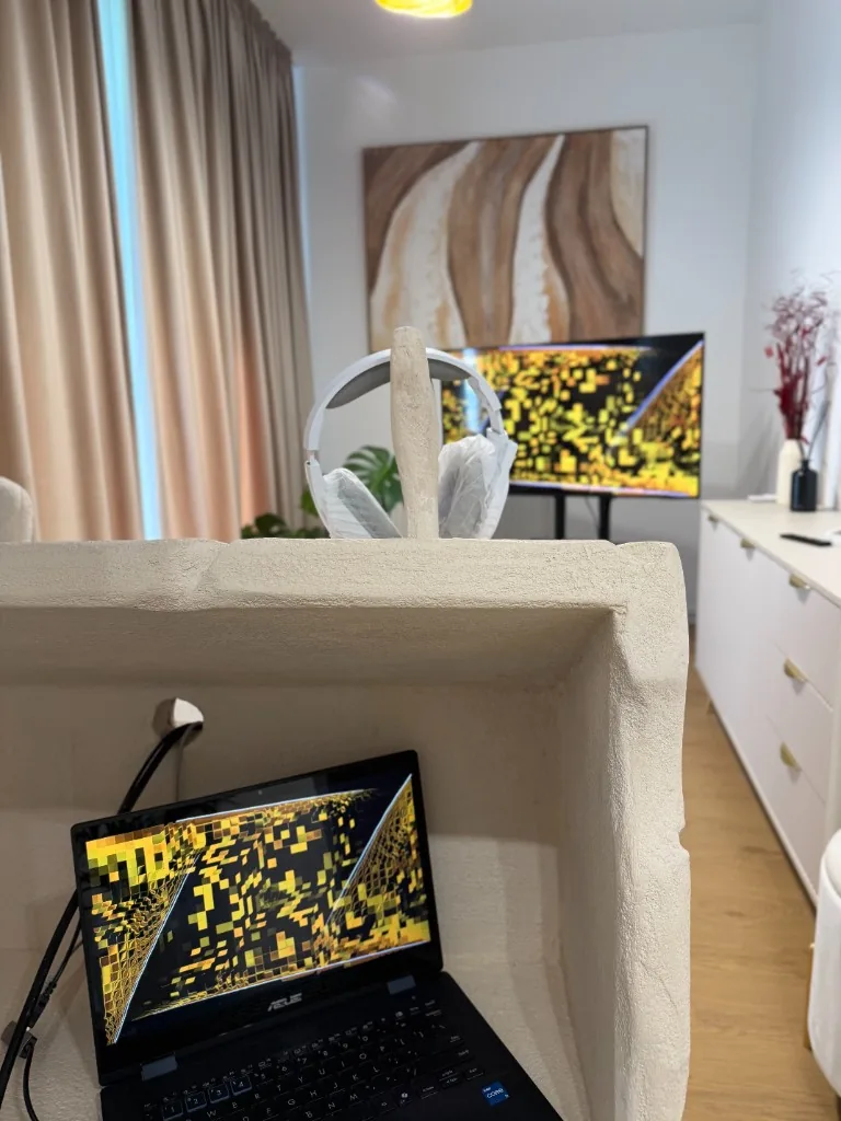 Sesiune NeurOptimal cu laptop și ecran mare afișând pattern-uri de antrenament cerebral, într-o sală de clinică Synaptica Cluj